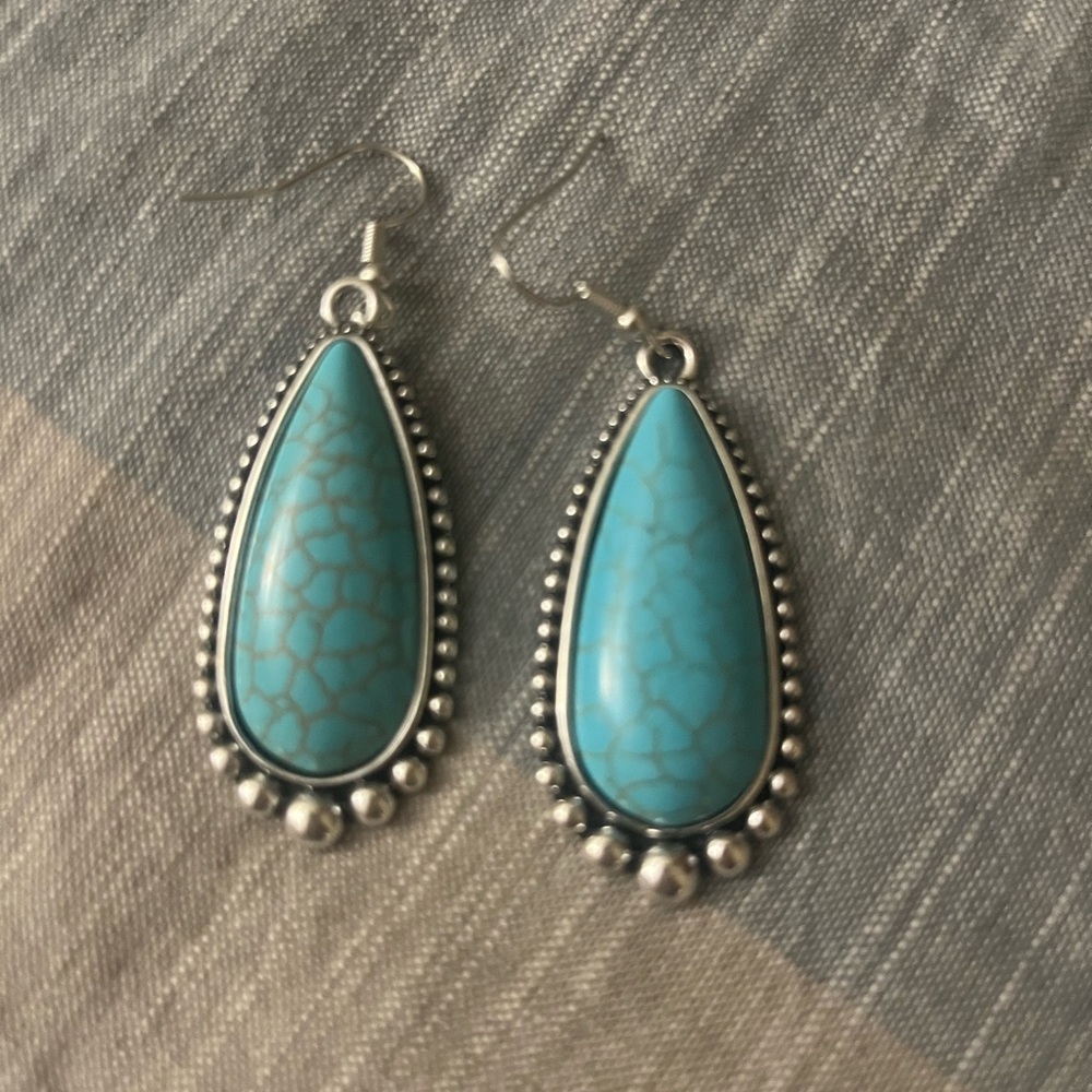 Brand new pair of silver earrings with turquoise color center stone